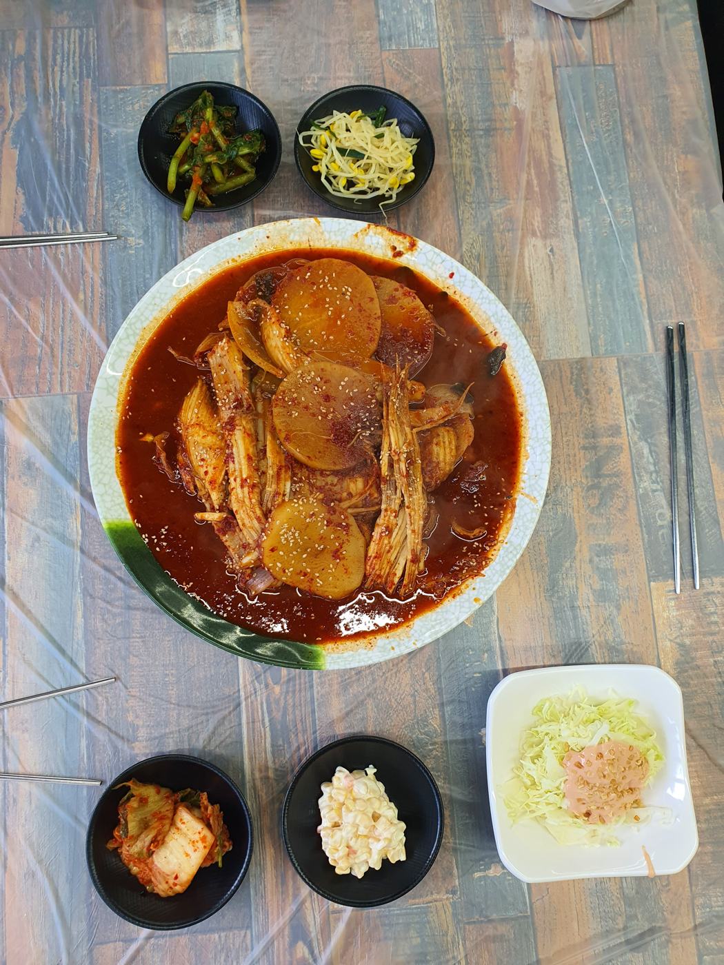 무와 생선이 담긴 생선찜과 기본 반찬 한 상